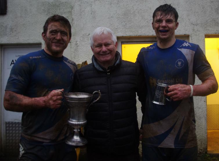 Blues skipper Matty Phillips (left) with Bishop Cup and Roy James Memorial man of match Liam Manwaring (right) with Gelly James (centre)